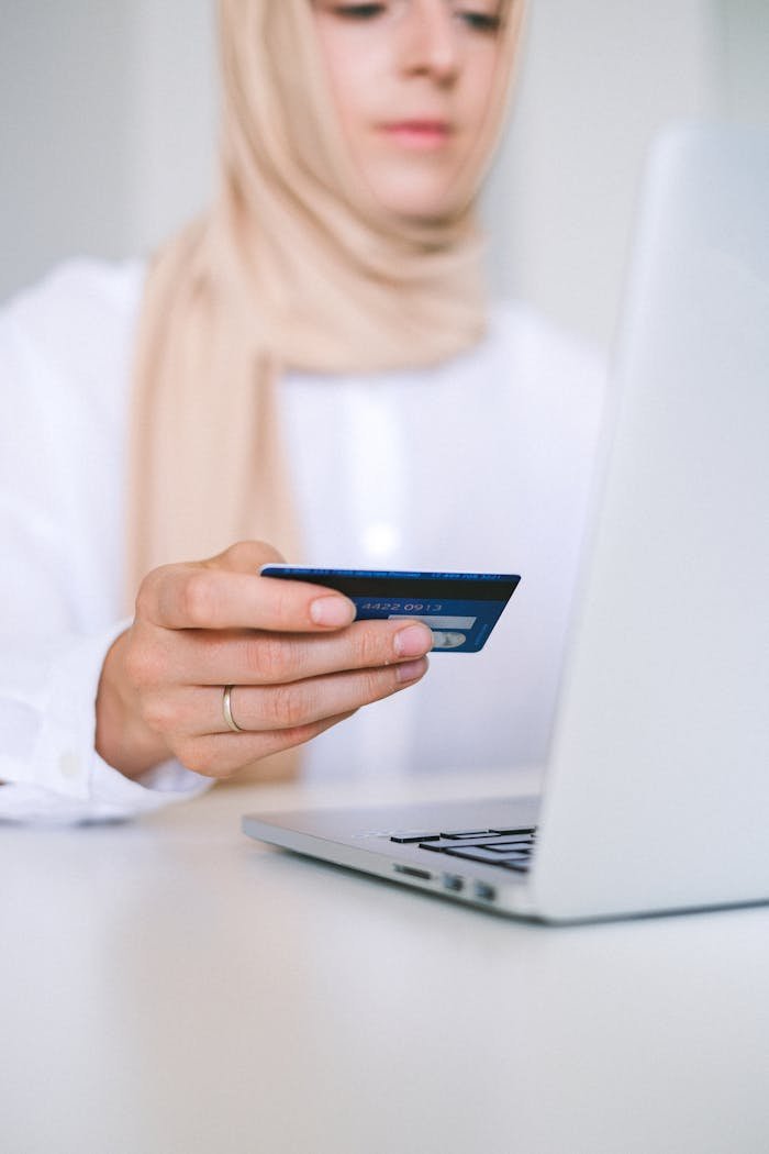 A woman using a laptop and credit card for an online shopping transaction.